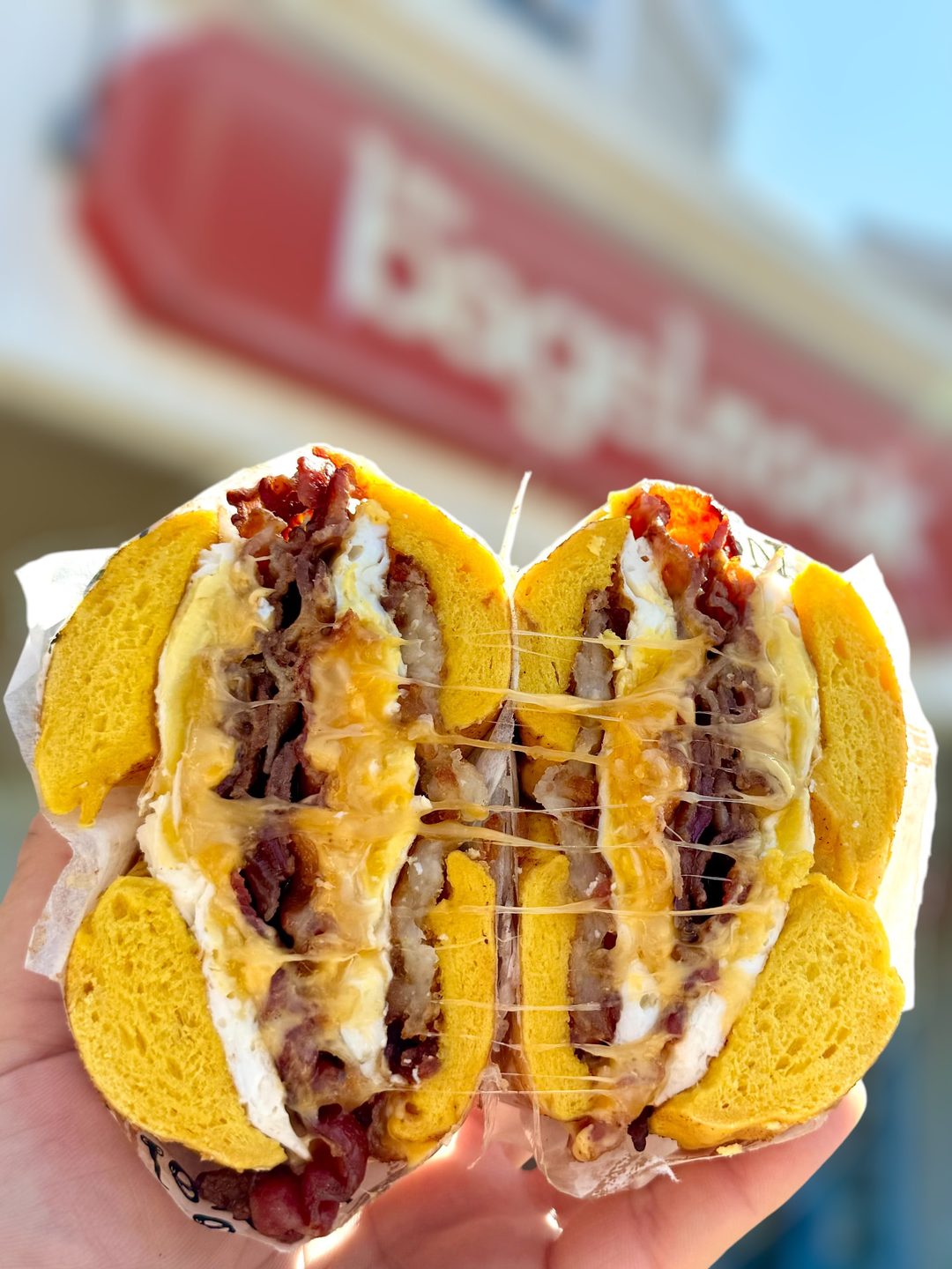 A loaded breakfast sandwich bagel with egg, bacon and melted cheese